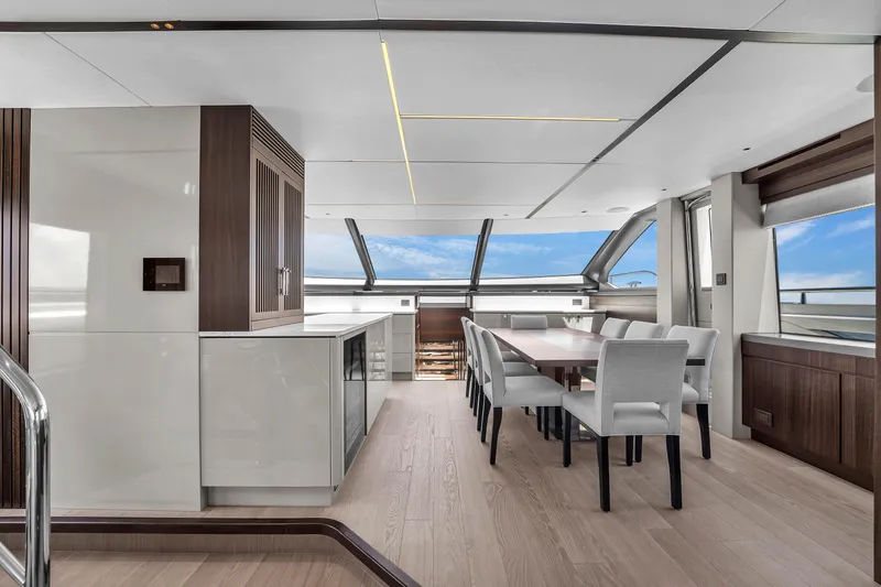 Worth The Wait Yacht Photos Pics Luxurious interior of 2024 Sunseeker Ocean 182 yacht with modern dining area and panoramic windows.