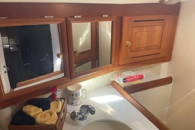 Aquavit Yacht Photos Pics 2001 Tartan 3700 yacht bathroom with wooden cabinets and sink area.