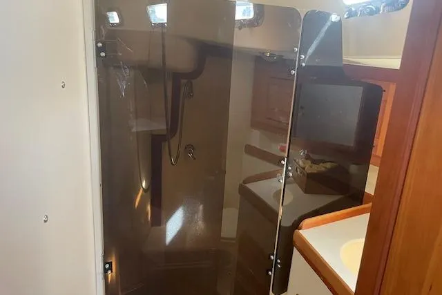 Aquavit Yacht Photos Pics Interior of 2001 Tartan 3700 yacht bathroom with shower and wooden cabinetry.