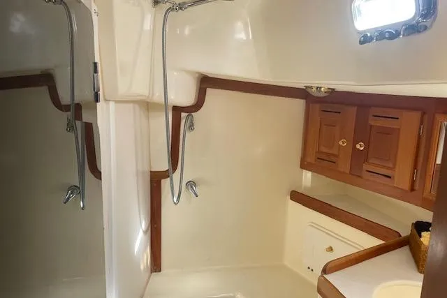 Aquavit Yacht Photos Pics Tartan 3700 yacht bathroom interior, featuring wooden cabinets and a shower, 2001 model.