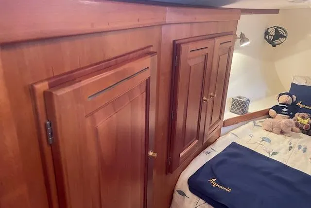 Aquavit Yacht Photos Pics Cozy cabin interior of 2001 Tartan 3700 sailboat with wooden cabinetry and bedding.