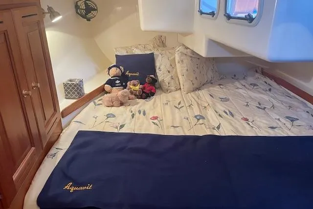 Aquavit Yacht Photos Pics Cozy cabin interior of 2001 Tartan 3700 sailboat with floral bedding and plush toys.