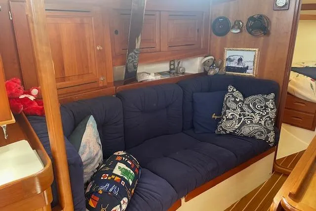 Aquavit Yacht Photos Pics Cozy interior of 2001 Tartan 3700 sailboat with blue cushions and wooden cabinetry.