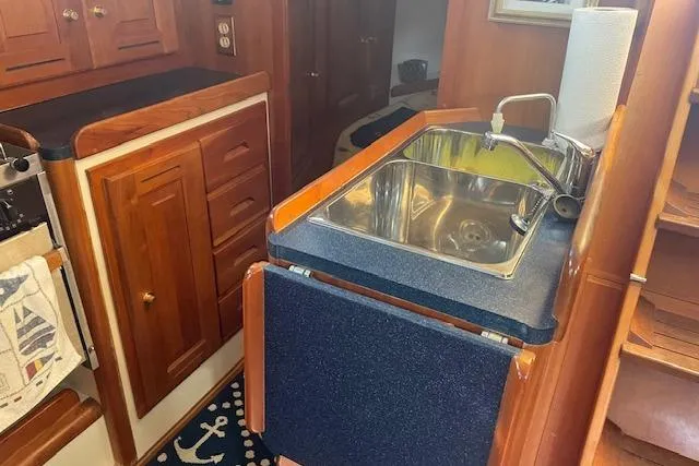 Aquavit Yacht Photos Pics 2001 Tartan 3700 yacht kitchen with wooden cabinets and stainless steel sink.
