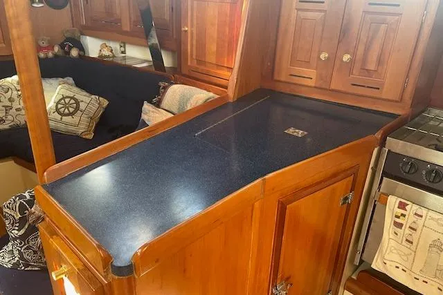 Aquavit Yacht Photos Pics Interior of a 2001 Tartan 3700 sailboat with wooden cabinetry and blue countertop.