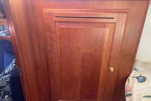 Aquavit Yacht Photos Pics Wooden cabinet door inside a 2001 Tartan 3700 sailboat, featuring a simple design.