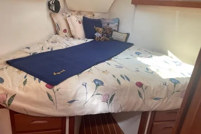 Aquavit Yacht Photos Pics Cozy cabin bed in 2001 Tartan 3700 sailboat with floral bedding and plush toys.