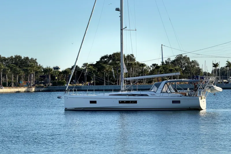  Yacht Photos Pics 2020 Beneteau Oceanis 51.1 sailboat anchored in calm waters near a marina.