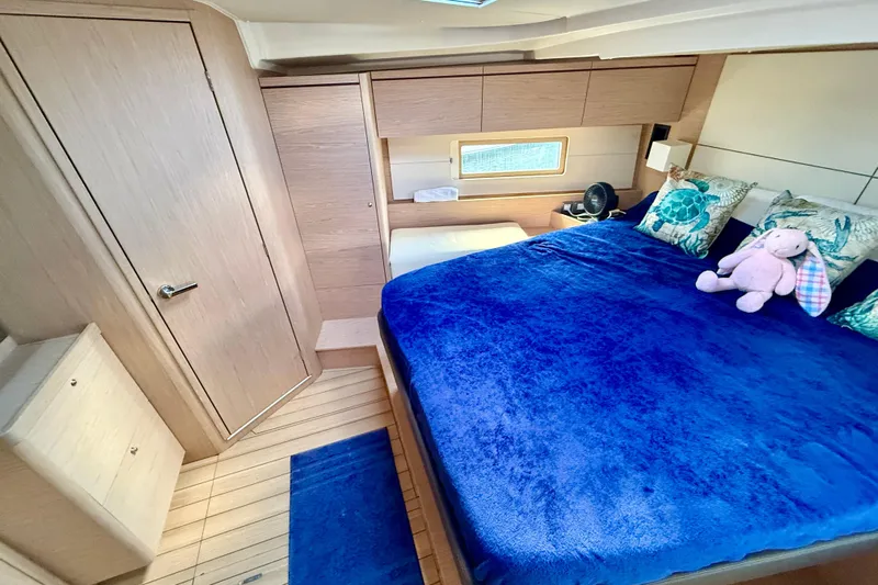  Yacht Photos Pics Luxurious cabin interior of 2020 Beneteau Oceanis 51.1 with plush bedding and nautical decor.