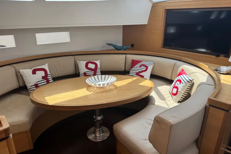  Yacht Photos Pics Luxurious interior of 2023 Garcia SLOOP ALUMINIUM 51 yacht with curved seating and decorative pillows.