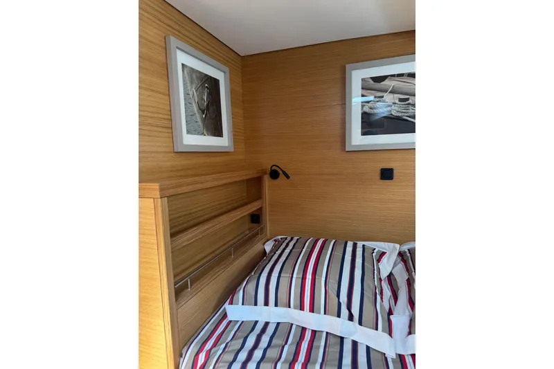 Yacht Photos Pics Cozy cabin interior of 2023 Garcia SLOOP ALUMINIUM 51 yacht with striped bedding.