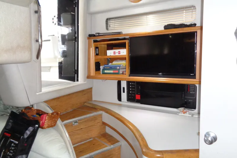 Snri Yacht Photos Pics Interior of 1991 Sea Ray 480 Sundancer with TV, books, and wooden stairs.