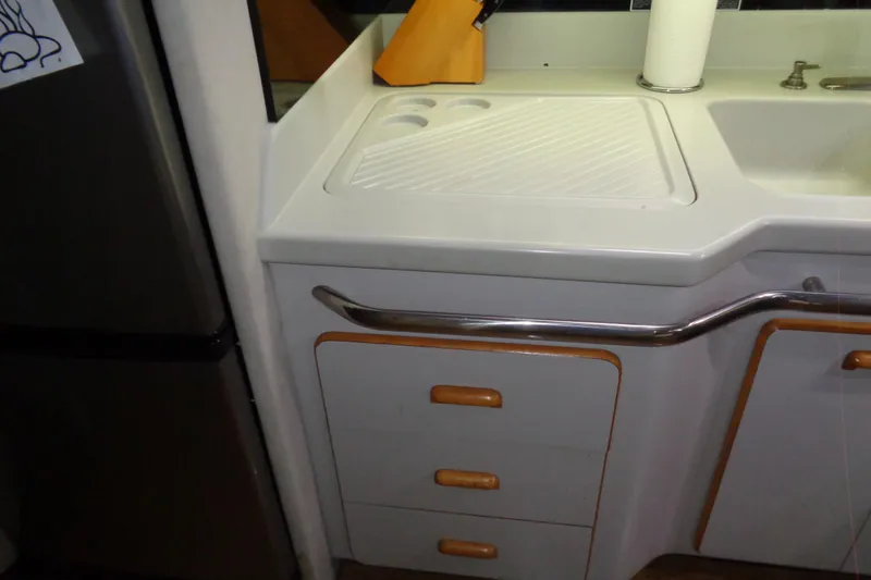 Snri Yacht Photos Pics 1991 Sea Ray 480 Sundancer kitchen area with sink, cutting board, and storage drawers.