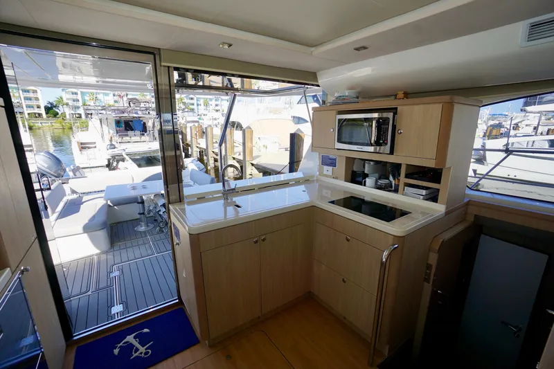  Yacht Photos Pics Interior of 2020 Aquila 44 Yacht with modern kitchen and outdoor seating area.