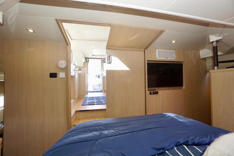  Yacht Photos Pics Interior of 2020 Aquila 44 Yacht with modern wood finish and cozy bedding.