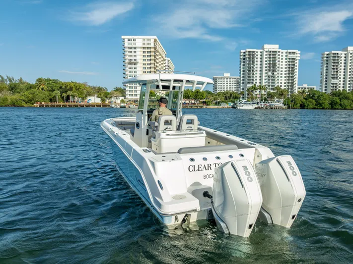 Clear To Close Yacht Photos Pics 2023 Boston Whaler 280 Outrage boat on water, city skyline in background.