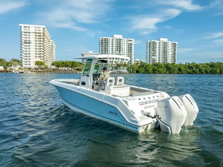 Clear To Close Yacht Photos Pics 2023 Boston Whaler 280 Outrage boat cruising on water near city skyline.