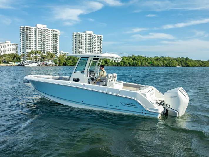 Clear To Close Yacht Photos Pics 2023 Boston Whaler 280 Outrage boat on water, cityscape background, clear sky.