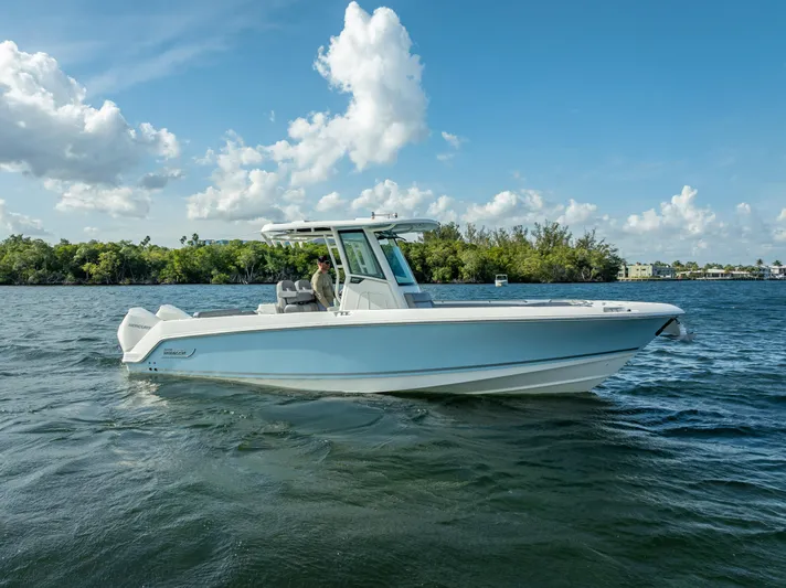 Clear To Close Yacht Photos Pics 2023 Boston Whaler 280 Outrage boat on a serene lake under a blue sky.