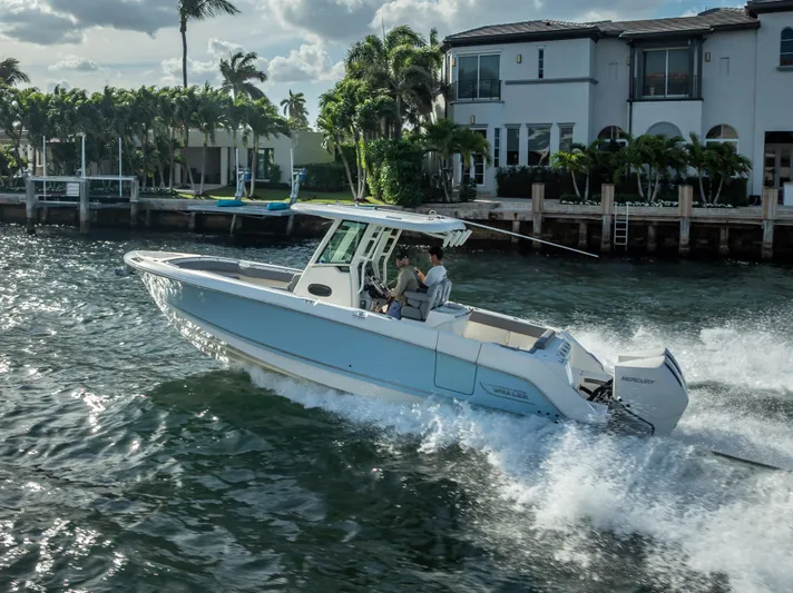 Clear To Close Yacht Photos Pics 2023 Boston Whaler 280 Outrage cruising on a sunny waterfront near luxury homes.