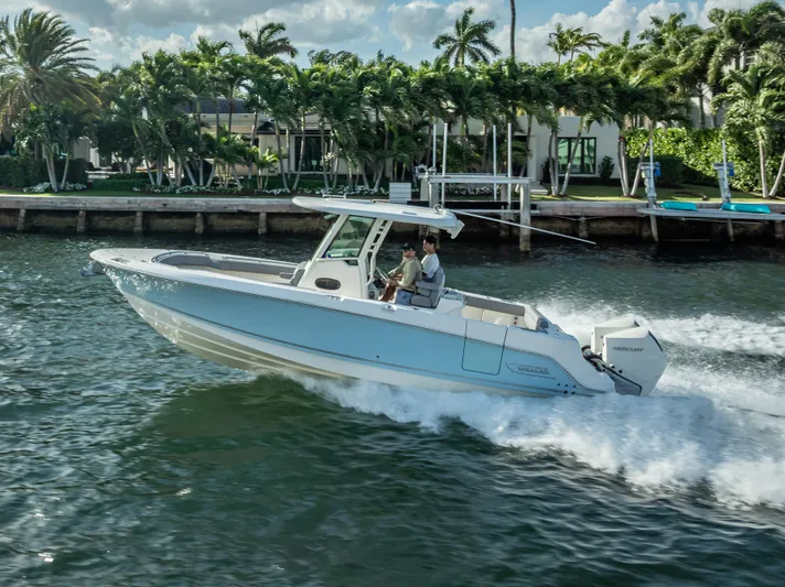 Clear To Close Yacht Photos Pics 2023 Boston Whaler 280 Outrage cruising on a sunny day near palm trees.