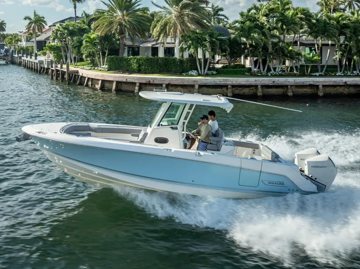 Clear To Close Yacht Photos Pics 2023 Boston Whaler 280 Outrage cruising on a scenic waterway with palm trees.