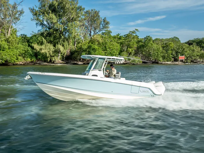 Clear To Close Yacht Photos Pics 2023 Boston Whaler 280 Outrage cruising on a scenic waterway with lush greenery.