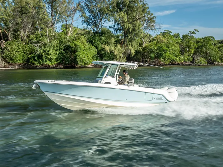 Clear To Close Yacht Photos Pics 2023 Boston Whaler 280 Outrage cruising on a scenic waterway with lush greenery.