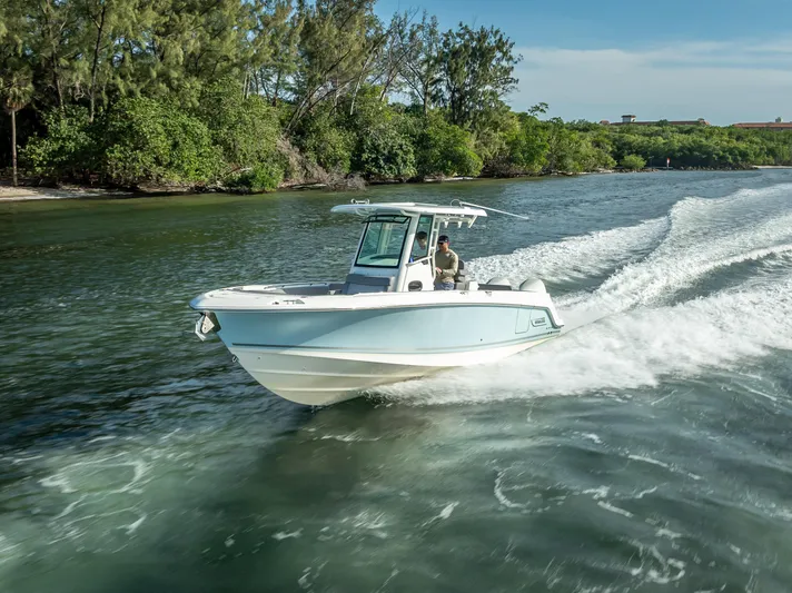 Clear To Close Yacht Photos Pics 2023 Boston Whaler 280 Outrage cruising on a scenic waterway with lush greenery.