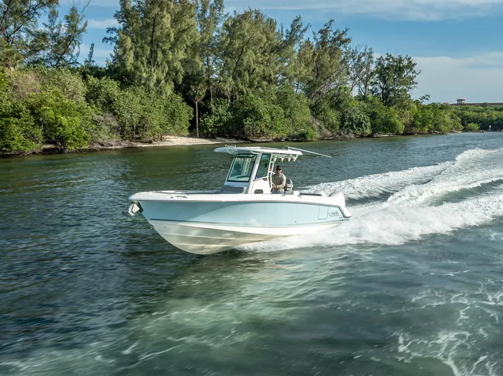 Clear To Close Yacht Photos Pics 2023 Boston Whaler 280 Outrage cruising on a scenic waterway with lush greenery.