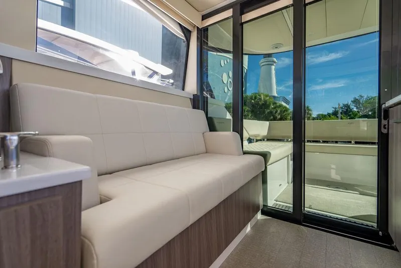 2021 Regal 38 Xo Yacht Photos Pics 2021 Regal 38 XO yacht interior with beige seating and glass doors.
