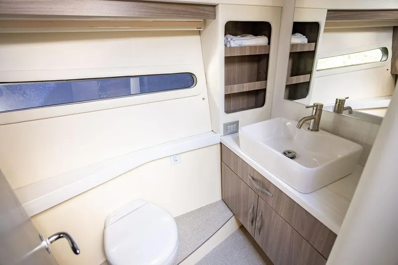 2021 Regal 38 Xo Yacht Photos Pics 2021 Regal 38 XO yacht bathroom with modern sink, toilet, and storage shelves.