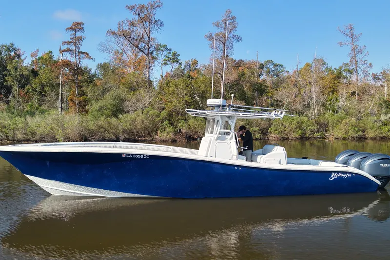 Yacht Photos Pics 2006 Yellowfin 36 Offshore boat on calm river, surrounded by lush trees.