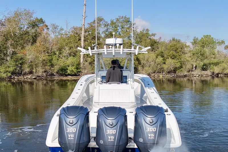  Yacht Photos Pics 2006 Yellowfin 36 Offshore boat with triple Yamaha engines on a calm river.
