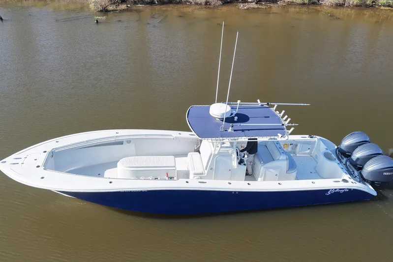  Yacht Photos Pics 2006 Yellowfin 36 Offshore boat with triple outboard engines on calm water.