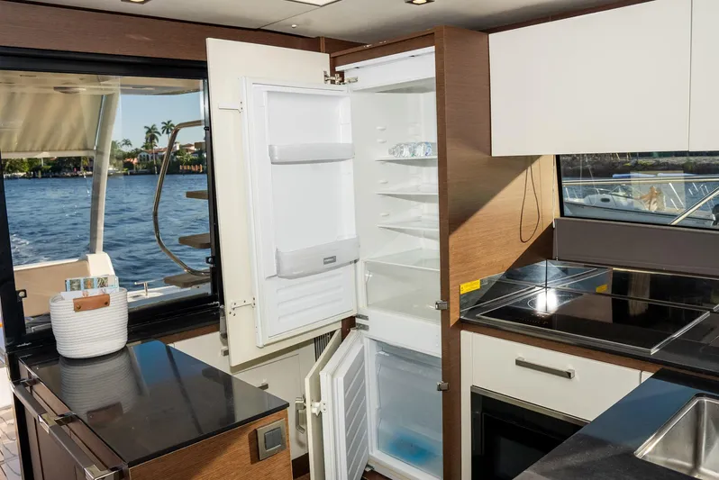 Knightlife Yacht Photos Pics Luxurious kitchen interior on a 2017 Prestige 630 yacht with open fridge and ocean view.