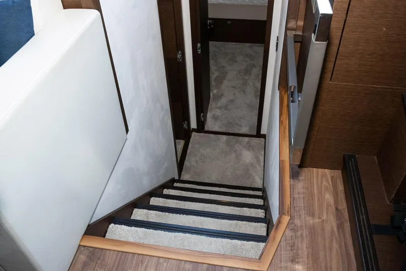 Knightlife Yacht Photos Pics Staircase inside 2017 Prestige 630 yacht, featuring carpeted steps and wooden accents.