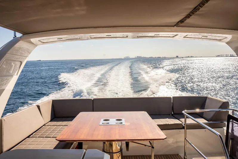 Knightlife Yacht Photos Pics Prestige 630 yacht cruising on open sea, rear view with seating and table, 2017 model.