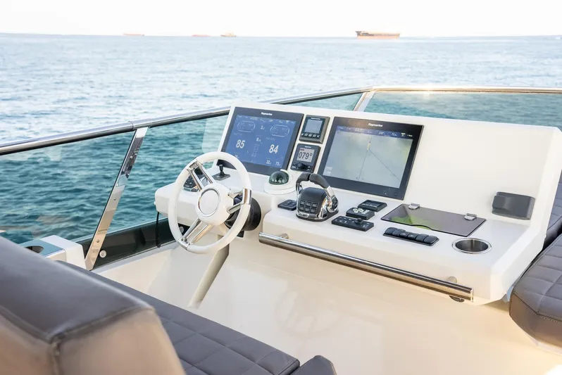 Knightlife Yacht Photos Pics Helm of 2017 Prestige 630 yacht with modern navigation equipment, overlooking the ocean.