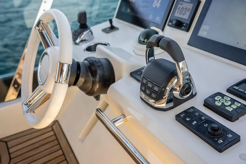Knightlife Yacht Photos Pics Control panel of a 2017 Prestige 630 yacht with steering wheel and navigation instruments.