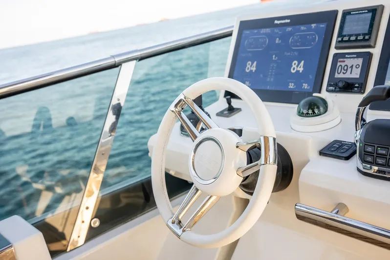 Knightlife Yacht Photos Pics Steering wheel and dashboard of a 2017 Prestige 630 yacht on open water.
