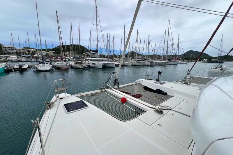 Ile En Ile Yacht Photos Pics 2018 Lagoon 42 catamaran docked in a marina with surrounding sailboats.