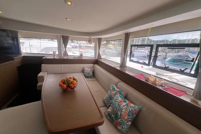 Ile En Ile Yacht Photos Pics Interior of 2018 Lagoon 42 catamaran with cozy seating, table, and marina view.