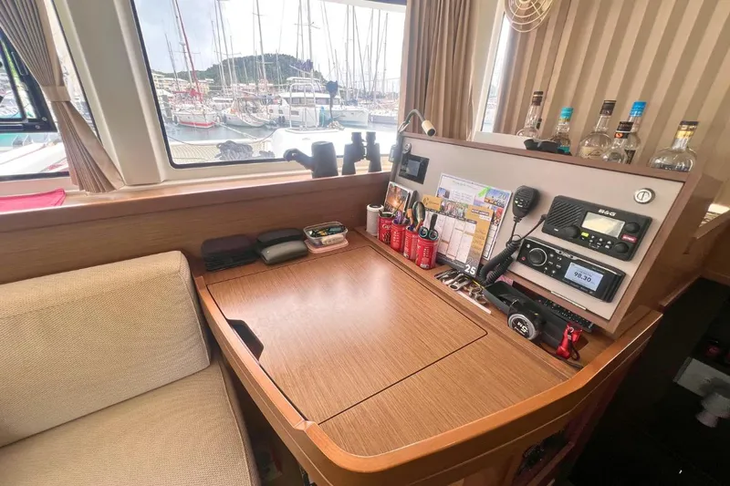 Ile En Ile Yacht Photos Pics Navigation station inside a 2018 Lagoon 42 catamaran, featuring equipment and marina view.