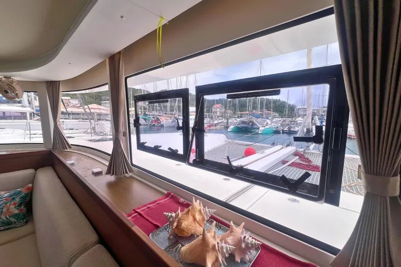 Ile En Ile Yacht Photos Pics Interior view of 2018 Lagoon 42 yacht with marina backdrop through windows.