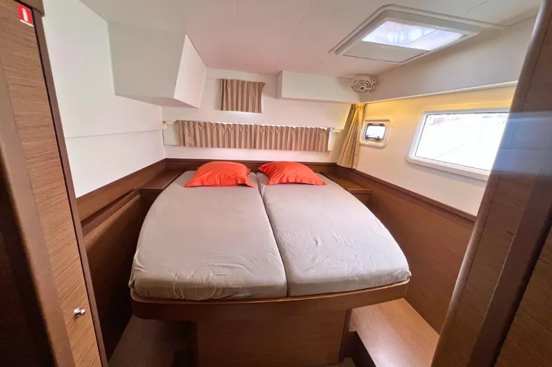 Ile En Ile Yacht Photos Pics Luxurious cabin interior of 2018 Lagoon 42 catamaran with double bed and orange pillows.