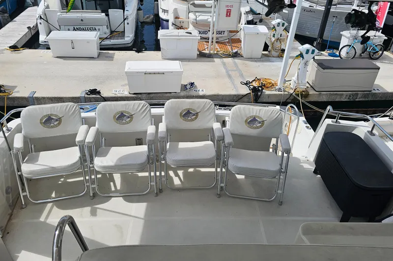 La Bella Vita Yacht Photos Pics 2004 Carver 444 Cockpit Motor Yacht with white chairs on deck at marina.