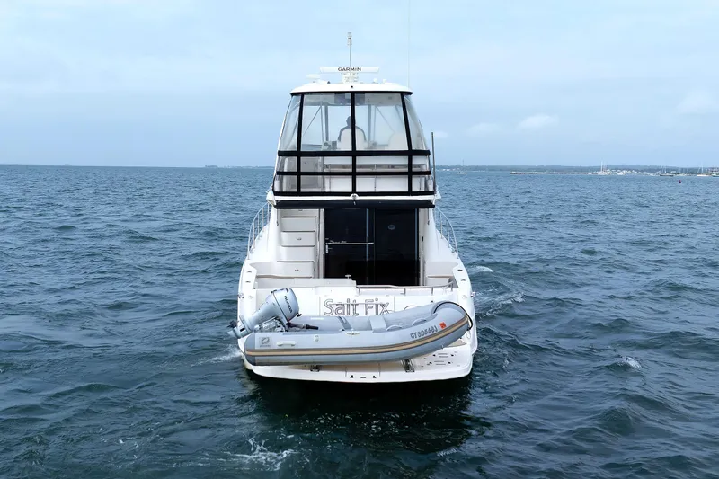  Yacht Photos Pics 2010 Sea Ray 520 Sedan Bridge yacht on open water, rear view with dinghy attached.