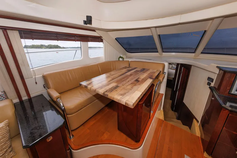  Yacht Photos Pics Luxurious interior of 2010 Sea Ray 520 Sedan Bridge yacht with wooden table and leather seating.