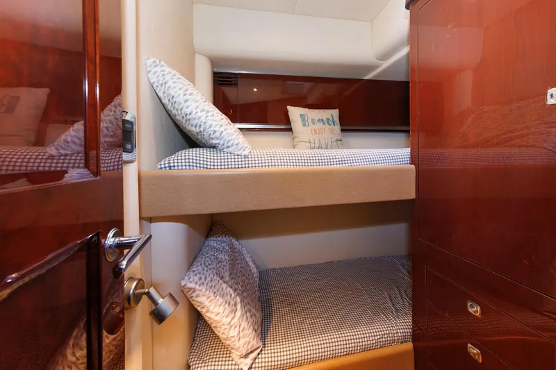  Yacht Photos Pics Bunk beds in 2010 Sea Ray 520 Sedan Bridge cabin with cozy pillows and wooden cabinetry.